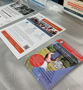 Printed flyers about the survey are spread out on a table.